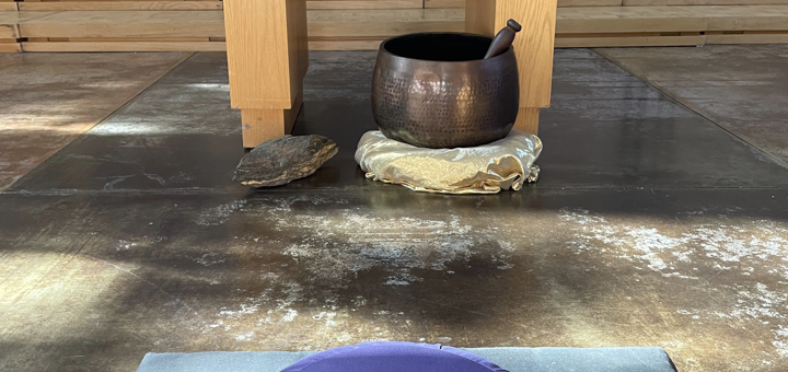 The Peace Sanctuary prepared for Meditation. Meditation cushion in front of the Singing Bowl and Vishnu Schist at the base of the Altar. A candle is lit on the Altar.