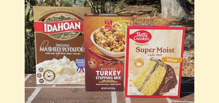 Photo of food items we are collecting for our Fall ICARE Project: boxed mashed potatoes, boxed stuffing mix, and boxed cake mix. Items are sitting on the Cloud of Witness wall with the inscription Peace Lutheran Church A House of Prayer for All People All are Welcome at the Table.