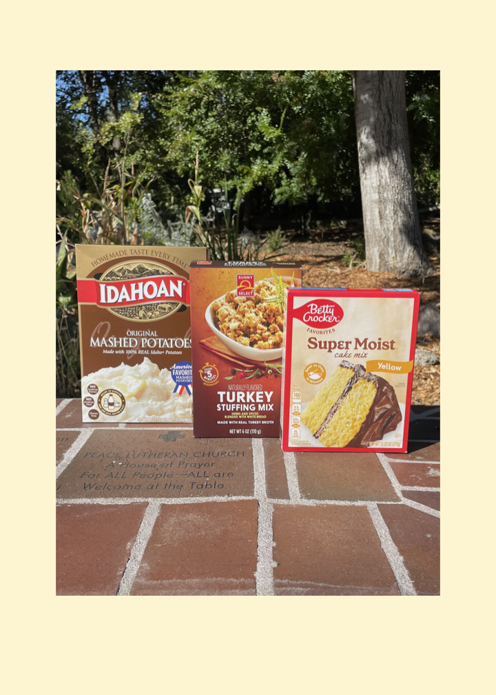 Photo of food items we are collecting for our Fall ICARE Project: boxed mashed potatoes, boxed stuffing mix, and boxed cake mix. Items are sitting on the Cloud of Witness wall with the inscription Peace Lutheran Church A House of Prayer for All People All are Welcome at the Table.