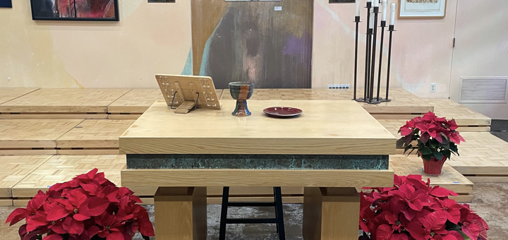 The Peace Altar prepared for Worship with the Chalice and poinsettia plants surrounding it.
