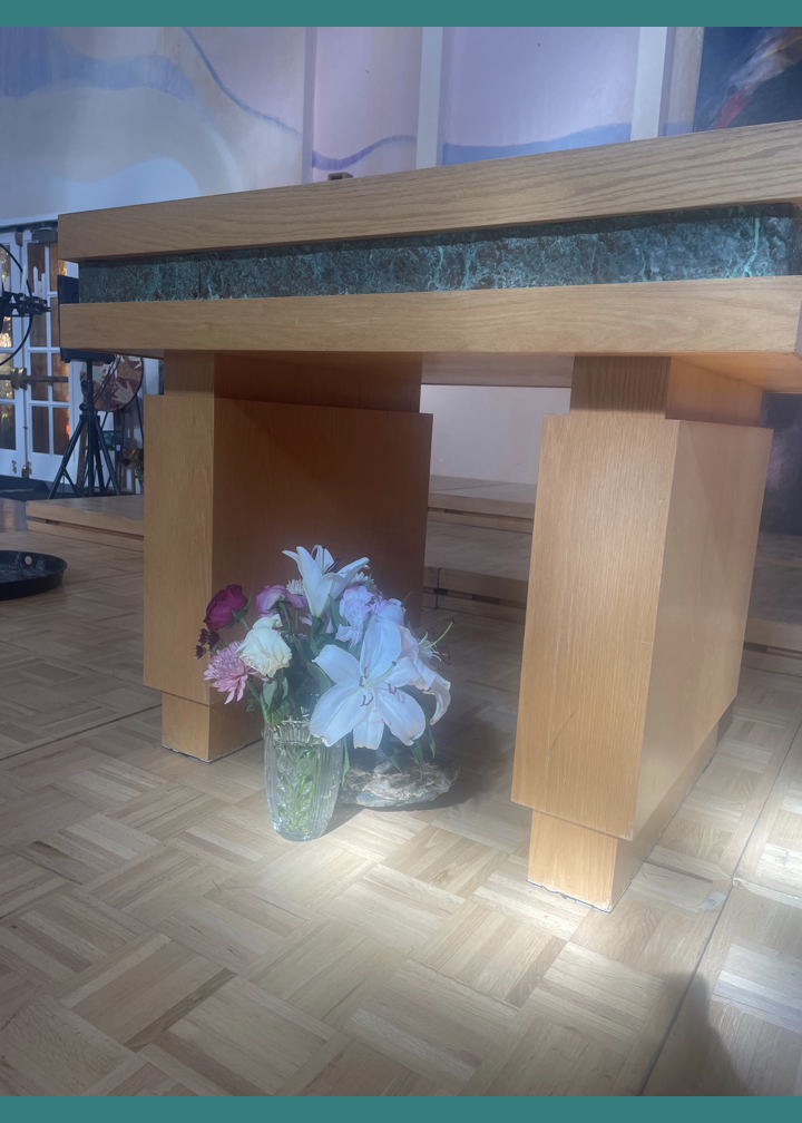 The Peace Sanctuary after Worship on November 9 2025. The altar with a flower arrangement of purple and white blooms from the Garden.