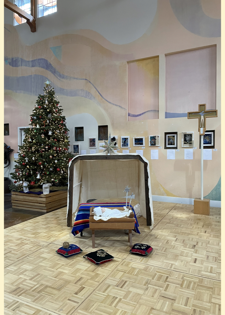 A photo of the Manger, Christmas Tree, and Processional Cross before Worship in the Peace Sanctuary on December 29th 2024.