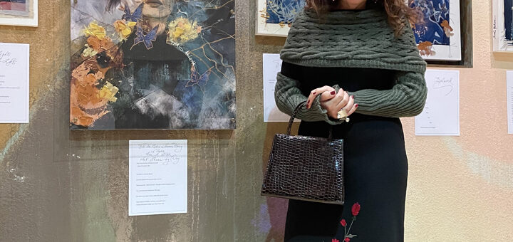 Artist Thais Ouzounian standing with her Advent Art Exhibit in the Peace Sanctuary.