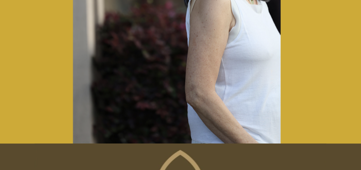 Smiling photo of Nora Hudson, Certified Vinyasa Yoga Instructor. Outline of Lotus drawing as a logo.