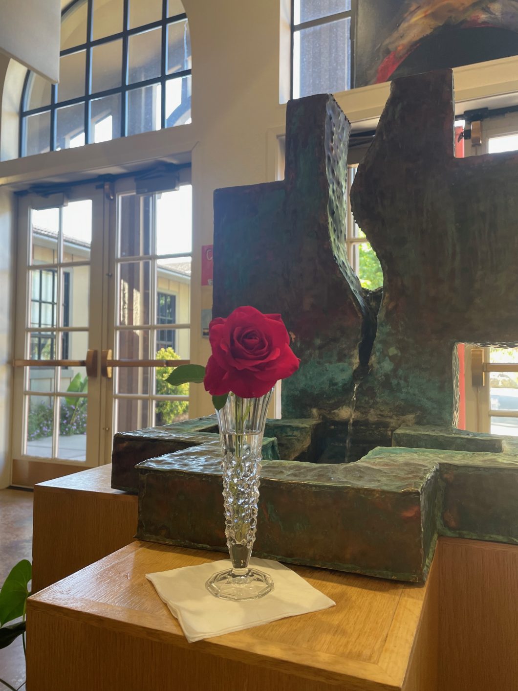 The Peace Baptismal Font with a Red Rose.